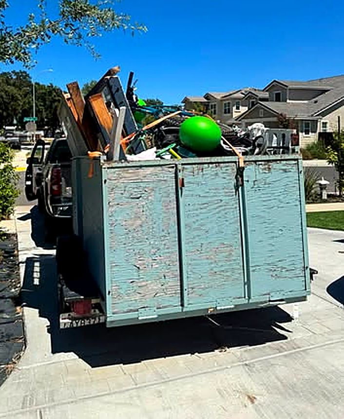 MickeyMo trailer piled with household junk in a residential neighborhood
