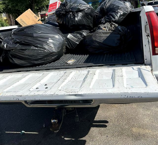 Pickup bed full of black trash bags